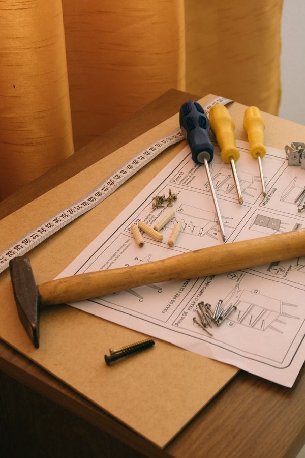 Hammer, screwdrivers and assembly instructions laid out for flat-pack furniture